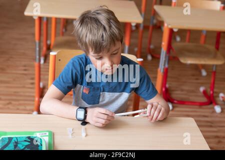 Der Junge wird vor der Klasse auf covid-19 getestet. Stockfoto