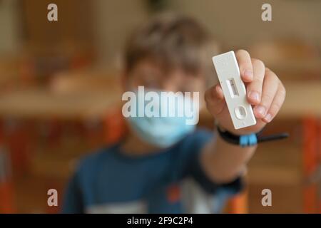Der Junge wird vor der Klasse auf covid-19 getestet. Stockfoto