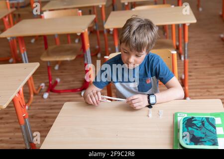 Der Junge wird vor der Klasse auf covid-19 getestet. Stockfoto