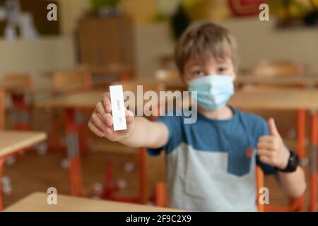 Der Junge wird vor der Klasse auf covid-19 getestet. Stockfoto