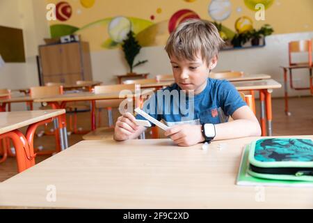 Der Junge wird vor der Klasse auf covid-19 getestet. Stockfoto