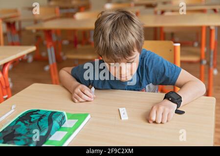Der Junge wird vor der Klasse auf covid-19 getestet. Stockfoto