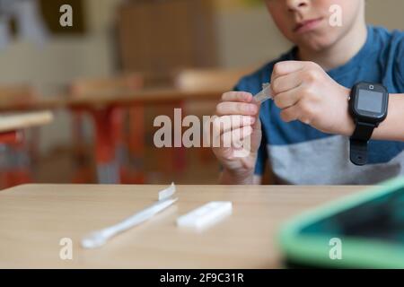 Der Junge wird vor der Klasse auf covid-19 getestet. Stockfoto