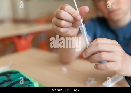 Der Junge wird vor der Klasse auf covid-19 getestet. Stockfoto