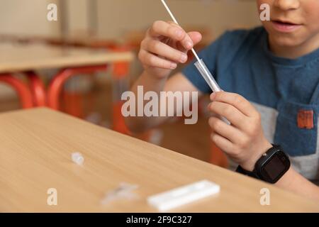 Der Junge wird vor der Klasse auf covid-19 getestet. Stockfoto