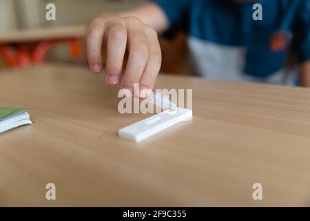 Der Junge wird vor der Klasse auf covid-19 getestet. Stockfoto