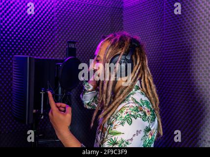 Junger Rasta, der in einem Aufnahmestudio singt Stockfoto