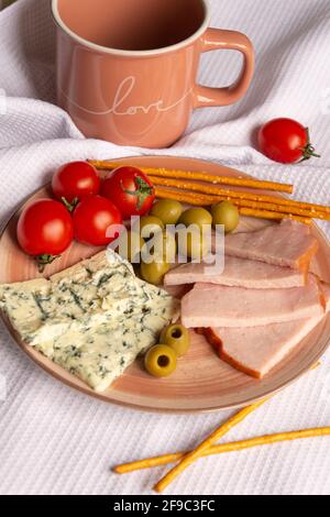 Teller mit Snacks und einer Tasse auf einer weißen Serviette Stockfoto