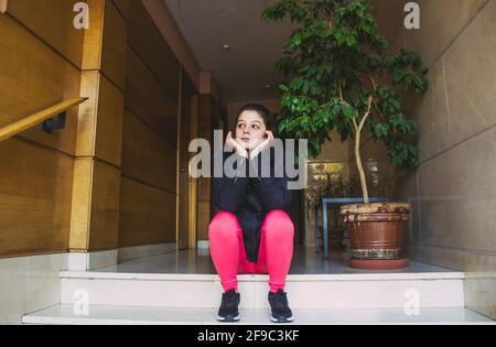 Junge Frau wartet in einem Portal Stockfoto
