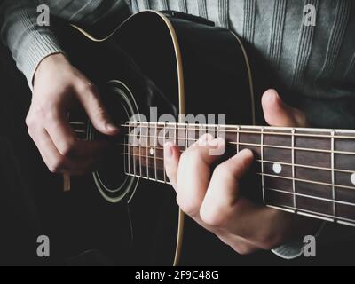 Die Hände des Mannes spielen aus der Nähe akustische Gitarre Stockfoto