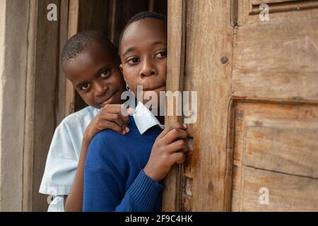 Dodoma, Tansania. 08-18-2019. Porträt zweier schwarzer Mädchen am Eingang des Klassenzimmers während eines Morgens in einer ländlichen Schule in Tansania. Stockfoto