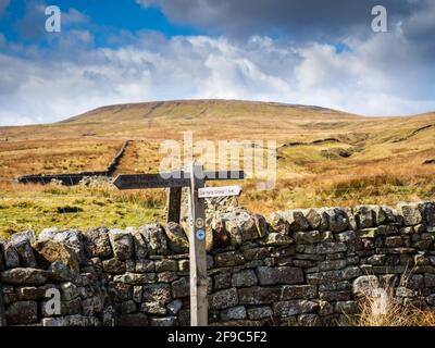 Alte hölzerne Wegweiser und eine trockene Steinmauer weisen auf den Weg über die Berge. Stausee des Narbe House. Nidderdale. Yorkshire Dales Stockfoto