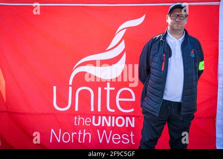 Senior Steward, Colin Organisator der heutigen Veranstaltung, steht bei einem Protest in der Nähe eines Spruchbanners, der die Beendigung des Feuers und die Wiedererlanung fordert. Die Unite Union setzt ihre Demonstration vor dem Busbahnhof in Queens Road fort. Gewerkschaftsmitglieder sagten, dass das Busunternehmen Go North West von seinen Fahrern erwarte, dass sie mehr Stunden für das gleiche Geld arbeiten, und nannten es eine ‘Feuer- und Wiederanstellungstaktik’. Stockfoto