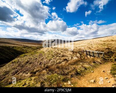 Ein Frühlingstag über Angram Moor in Yorkshire mit Little Whernside und einem Steg in der Ferne. Wogende Wolken bilden die Szene. Stockfoto