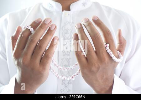 muslimischer Mann, der betet und Gebetsperlen hält Stockfoto