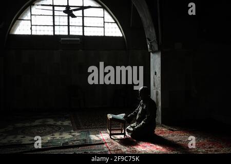 Maarrat Misrin, Syrien. April 2021. Ein Syrer liest den Koran in der Moschee der Stadt Maarrat Misrin während des muslimischen Fastenmonats Ramadan. Quelle: Anas Alkharboutli/dpa/Alamy Live News Stockfoto