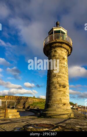 Whitby Harbour Leuchtturm im Sommer mit blauem Himmel und goldener Sonne. Yorkshire Touristenort. Stockfoto