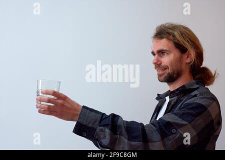 Lächelnder hispanischer Mann mit einem Glas Wasser isoliert auf Ein weißer Hintergrund Stockfoto