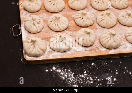 Schlanke Reihen von ungekochten georgischen Khinkali Stockfoto