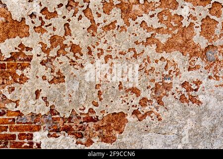 Textur von rot verwitterter Farbe an der alten Gebäudewand Stockfoto