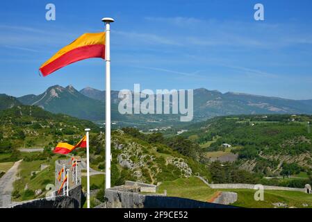 Landschaftlich reizvolle Landschaft mit Blick auf die Stadtmauer von Zitadelle und die Gemeindeflaggen von Sisteron in Alpes-de-Haute-Provence, Frankreich. Stockfoto