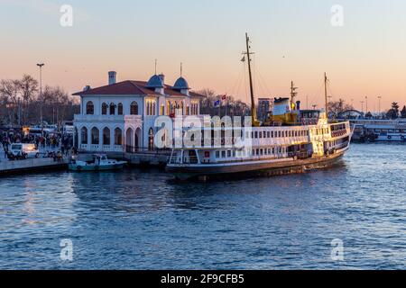 Blick auf die Fähre und wartende Passagiere am Kadikoy Besiktas Fähranleger bei Sonnenuntergang in Kadikoy, Istanbul, Türkei am 18. März 2021. Stockfoto