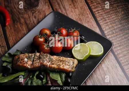 Teller Lachsfilet mit Spinat, Zitrone und Kirschtomaten Stockfoto