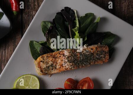 Teller Lachsfilet mit Spinat, Zitrone und Kirschtomaten Stockfoto