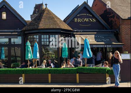 Windsor, Großbritannien. April 2021. Die Menschen genießen die Sonne in der Browns Brasserie. Einheimische und Besucher kamen heute nach Windsor, um an seinem Begräbnistag Prinz Philip ihren Respekt zu zollen, doch viele folgten dem Rat und blieben wegen der anhaltenden Covid-19-Pandemie weg. In der Stadt gab es eine starke Präsenz bewaffneter Polizisten zusammen mit zahlreichen RBWM-Stewards. Das Begräbnis für den Herzog von Edinburgh war eine private Veranstaltung, die in der St. George's Chapel auf dem Gelände des Windsor Castle stattfand. Quelle: Maureen McLean/Alamy Stockfoto