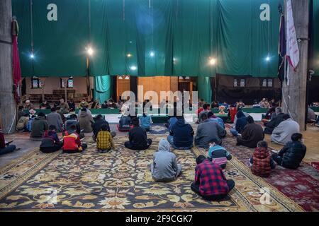 Srinagar, Indien. April 2021. Kaschmiri-Muslime rezitieren das islamische heilige Buch Koran während der Gemeinderezitation des Heiligen Koran am 4. Tag des Ramadan in an Imam Badah in Srinagar.der heiligste Monat des Islams im Ramadan ist eine Zeit des intensiven Gebets, des Fastens von Sonnenaufgang bis Sonnenuntergang und nächtlicher Feste. Khatam Al-Quran ist eine Zeremonie, die normalerweise gegen Ende des Ramadan von Muslimen abgehalten wird. Die Einhaltung markiert den Abschluss der Lektüre der 30 Kapitel (Juzuk) des Al-Quran. Kredit: SOPA Images Limited/Alamy Live Nachrichten Stockfoto