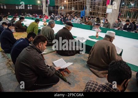 Srinagar, Indien. April 2021. Kaschmiri-Muslime rezitieren das islamische heilige Buch Koran während der Gemeinderezitation des Heiligen Koran am 4. Tag des Ramadan in an Imam Badah in Srinagar.der heiligste Monat des Islams im Ramadan ist eine Zeit des intensiven Gebets, des Fastens von Sonnenaufgang bis Sonnenuntergang und nächtlicher Feste. Khatam Al-Quran ist eine Zeremonie, die normalerweise gegen Ende des Ramadan von Muslimen abgehalten wird. Die Einhaltung markiert den Abschluss der Lektüre der 30 Kapitel (Juzuk) des Al-Quran. Kredit: SOPA Images Limited/Alamy Live Nachrichten Stockfoto