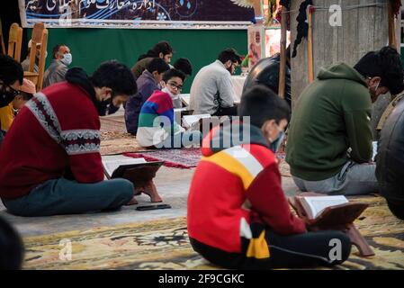 Srinagar, Indien. April 2021. Ein muslimischer Kid aus Kaschmir schaut während der Gemeinderezitation des islamischen heiligen Buches Koran am 4. Ramadan in an Imam Badah in Srinagar zu.der heiligste Monat des Islams im Ramadan ist eine Zeit des intensiven Gebets, des Fastens von Sonnenaufgang bis Sonnenuntergang und nächtlicher Feste. Khatam Al-Quran ist eine Zeremonie, die normalerweise gegen Ende des Ramadan von Muslimen abgehalten wird. Die Einhaltung markiert den Abschluss der Lektüre der 30 Kapitel (Juzuk) des Al-Quran. Kredit: SOPA Images Limited/Alamy Live Nachrichten Stockfoto