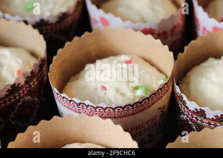 Roher Teig mit kandierten Früchten für Ostergebäck in Papierdosen, fertig zum Backen Stockfoto