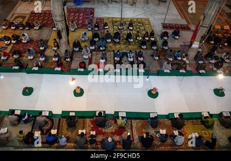 Srinagar, Indien. April 2021. Kaschmiri-Muslime rezitieren das islamische heilige Buch Koran während der Gemeinderezitation des Heiligen Koran am 4. Tag des Ramadan in an Imam Badah in Srinagar.der heiligste Monat des Islams im Ramadan ist eine Zeit des intensiven Gebets, des Fastens von Sonnenaufgang bis Sonnenuntergang und nächtlicher Feste. Khatam Al-Quran ist eine Zeremonie, die normalerweise gegen Ende des Ramadan von Muslimen abgehalten wird. Die Einhaltung markiert den Abschluss der Lektüre der 30 Kapitel (Juzuk) des Al-Quran. (Foto von Idrees Abbas/SOPA Images/Sipa USA) Quelle: SIPA USA/Alamy Live News Stockfoto