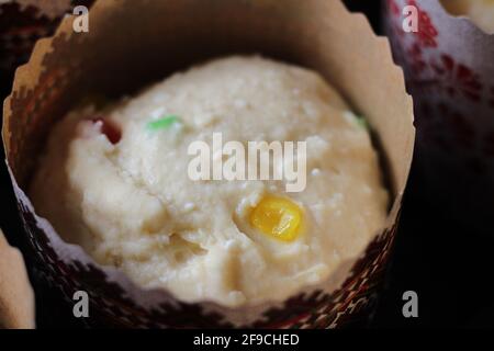 Roher Teig mit kandierten Früchten für Ostergebäck in Papierdosen, fertig zum Backen Stockfoto