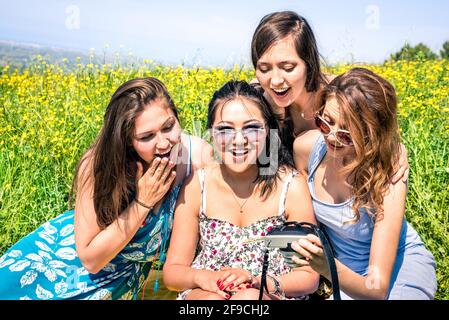 Multirassische Freundinnen auf dem Land picknicken und Fotos im Handumdrehen ansehen Digitalkamera - Happy Friendship Fun Konzept mit jungen Menschen Stockfoto