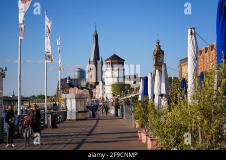 Die beliebte Rheinpromenade in Düsseldorf mit Lambertus-Kirche und historischem Burgturm. Stockfoto