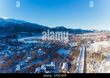 Wintersaison in Zakopane, Polen. Schneebedeckte Häuser Straßen und Wald mit Bergen im Hintergrund. Hochwertige Fotos Stockfoto