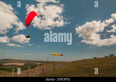 Bo Peep, Alciston, Lewes, East Sussex, Großbritannien. April 2021. Ein herrlicher heller Tag auf den Sussex-Daunen. Wärmer als spät mit einem lebhaften, angenehm kühlenden Wind aus dem Nordosten. Viele Aktivitäten auf den Downs, wie Hängegleiter und Gleitschirmflieger in die Luft fliegen und Läufer auf dem South Downs Way 50 Run vorbeiziehen. Kredit: David Burr/Alamy Live Nachrichten Stockfoto