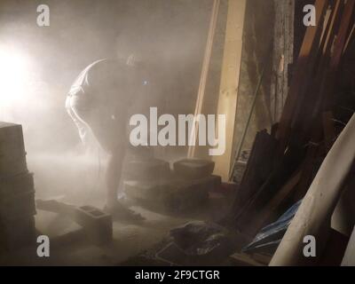 Bauarbeiter schneidet Zement in einer staubigen Werkstatt Stockfoto