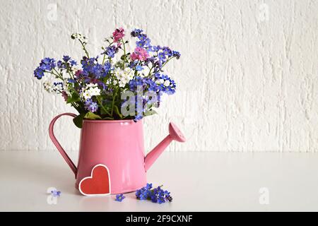 Muttertag Blumen in einem Gießeimer Stockfoto