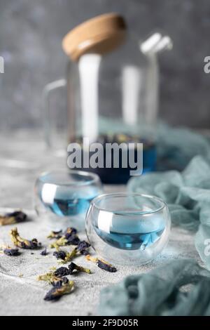 Blauer Bio-Tee Anchan, Clitoria, Butterfly Pea in einer Teekane und einer Tasse. Stockfoto