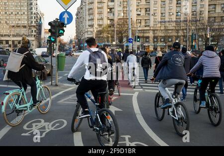 Bukarest, Rumänien - 01. April 2021: Menschen auf dem Fahrrad warten darauf, auf dem Radweg auf dem Siegesplatz in Bukarest, Rumänien, die Straße zu überqueren. Stockfoto