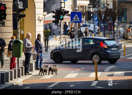 Bukarest, Rumänien - 01. April 2021: Die Menschen warten darauf, die Straße auf dem Radweg der Victory Avenue in Bukarest, Rumänien, zu überqueren. Stockfoto