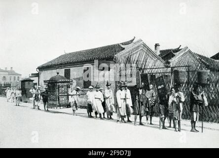 Hochzeitsprozession in China. Die Bildunterschrift dieses Fotos aus dem Jahr 1900 lautet: „Hochzeitsprozession. Braut in Sedan Stuhl von mehreren Männern in dieser luftdichten Affäre sie wird eingesperrt, um zu tragen, wo Zeremonie stattfinden Niemand durfte sie während der Prozession zu sehen. " Stockfoto