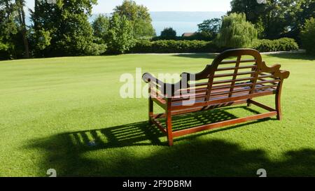 Unbesetzte Holzbank in einem Park mit Aussicht Stockfoto