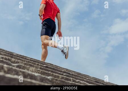 Rückansicht Foto von unten vom Körper eines männlichen Athleten Laufen auf der Treppe Stockfoto