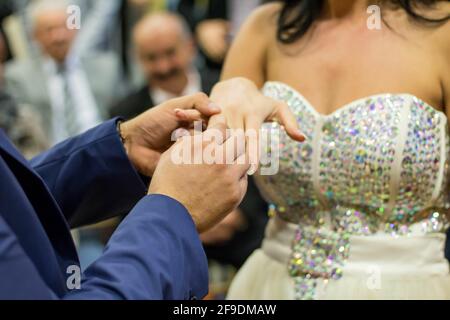 Nahaufnahme eines Bräutigams, der einen Ring aufsetzt Der Finger der Braut während der Hochzeitszeremonie Stockfoto