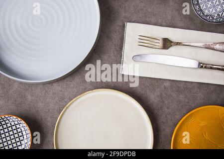 Eine Draufsicht auf leere Keramikplatten mit einer Gabel Und Messer auf einer Serviette auf dem Tisch Stockfoto
