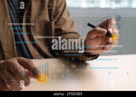 Geschäftsmann arbeiten Projekt und aktualisieren Gantt Software Diagramm Scheduling virtuell Diagramm- und Fortschrittsplanung Qualität und Kommunikation gantt on virtua Stockfoto